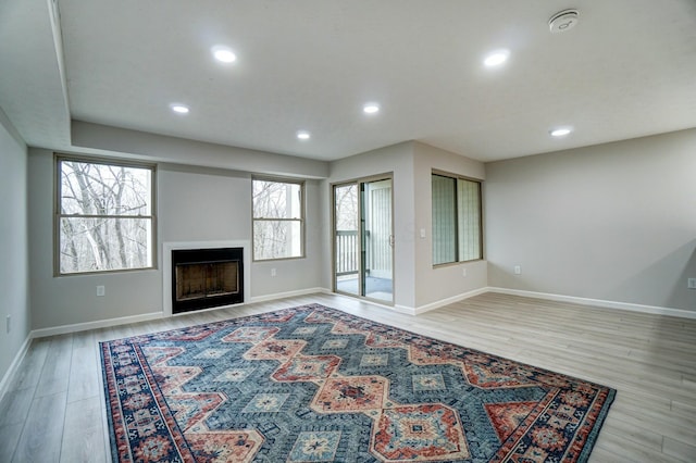 unfurnished living room with recessed lighting, light wood-style floors, and a fireplace