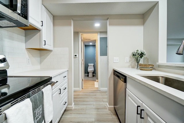 kitchen with a sink, tasteful backsplash, appliances with stainless steel finishes, and light countertops