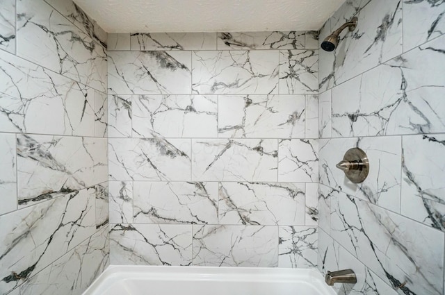 full bathroom with a textured ceiling and  shower combination