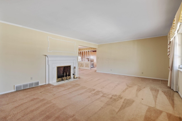 unfurnished living room with a fireplace with flush hearth, visible vents, crown molding, and carpet floors