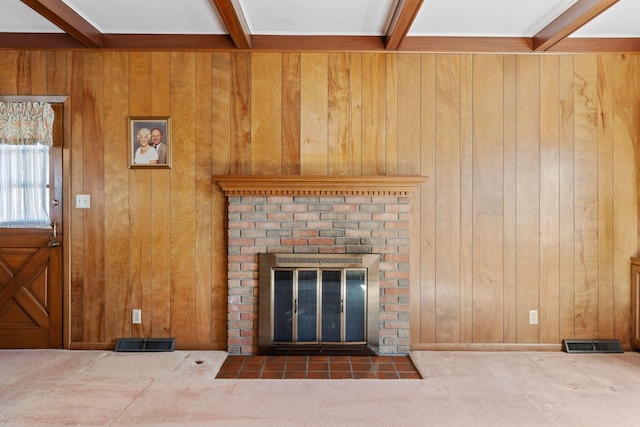 unfurnished living room featuring carpet, beam ceiling, a fireplace, and visible vents