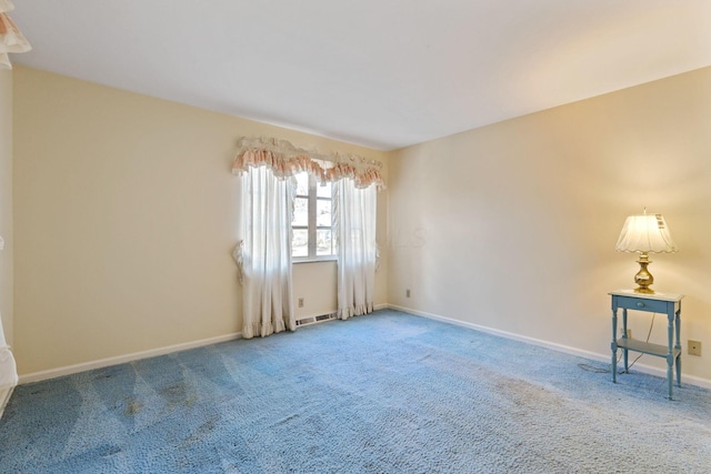 unfurnished room with carpet floors, visible vents, and baseboards