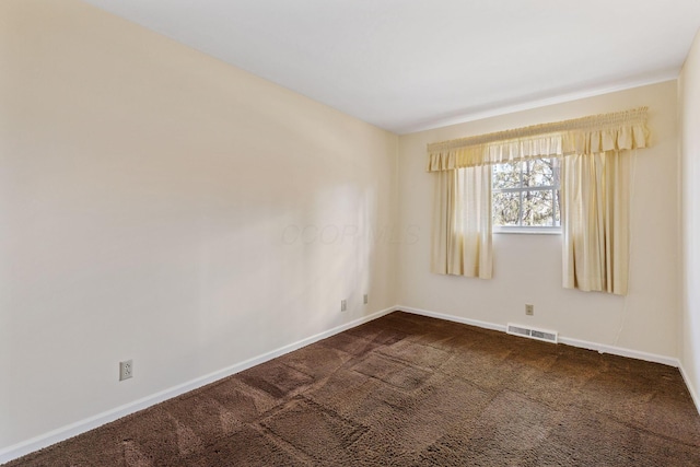 unfurnished room with dark colored carpet, visible vents, and baseboards