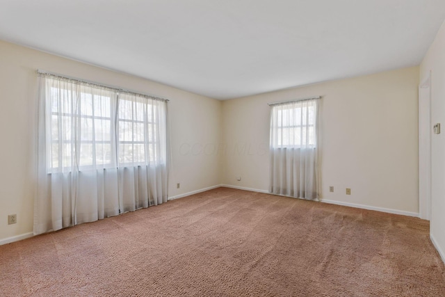 carpeted spare room with baseboards