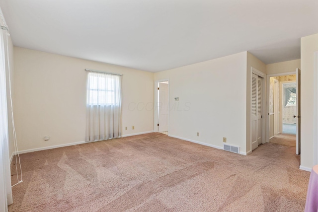 carpeted empty room with baseboards and visible vents