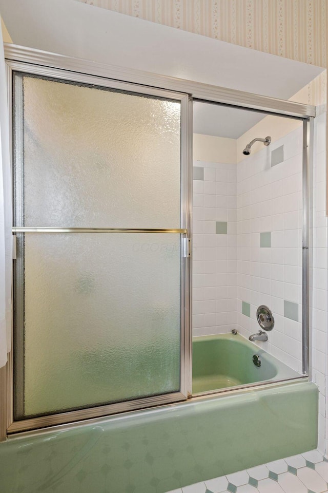 bathroom featuring shower / bath combination with glass door and wallpapered walls