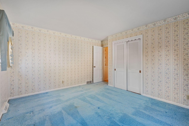 unfurnished bedroom featuring baseboards, carpet, visible vents, and wallpapered walls