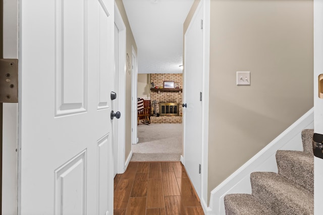 hallway with dark wood finished floors, stairway, and baseboards