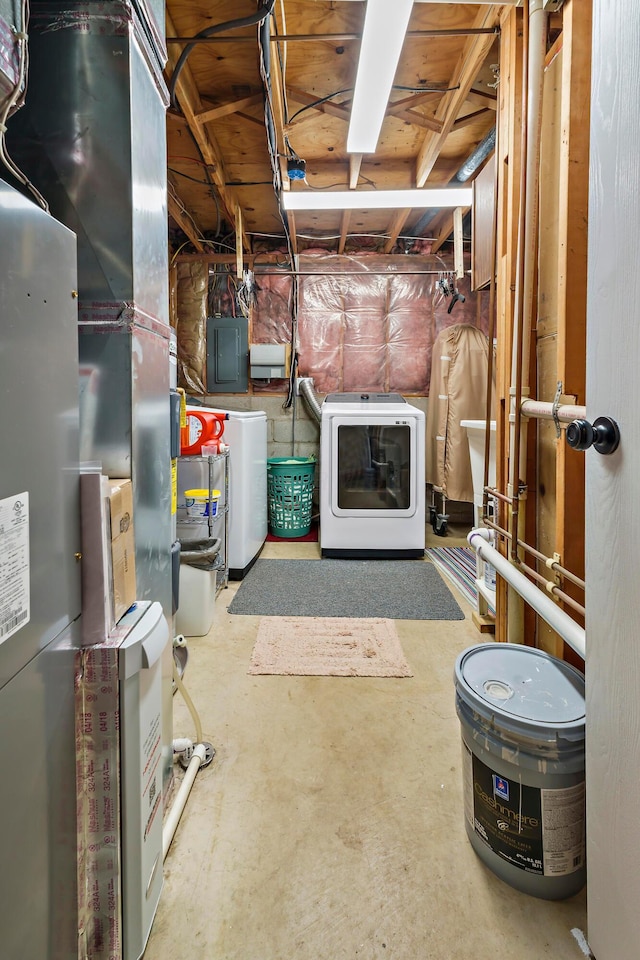 unfinished basement featuring heating unit, washer / dryer, and electric panel