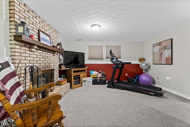 workout area with carpet floors, a fireplace, a textured ceiling, and baseboards