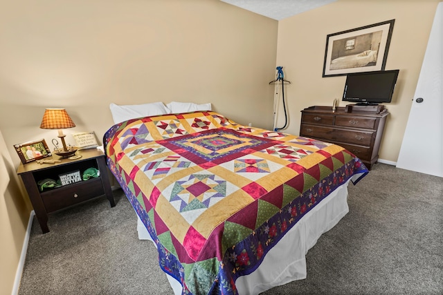 bedroom featuring baseboards and dark carpet