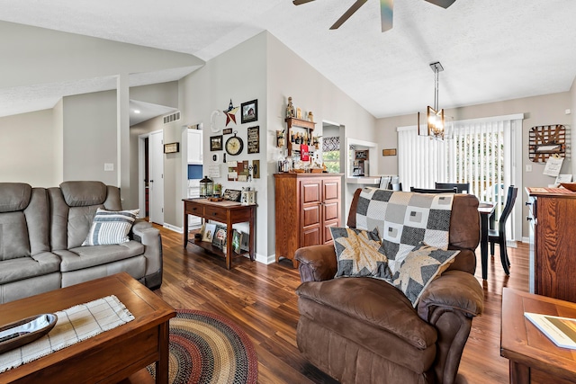 living room with visible vents, vaulted ceiling, wood finished floors, and ceiling fan with notable chandelier