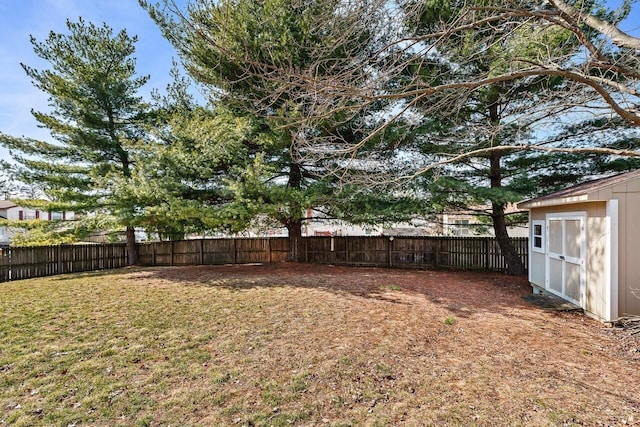 view of yard with an outbuilding, a fenced backyard, and a shed