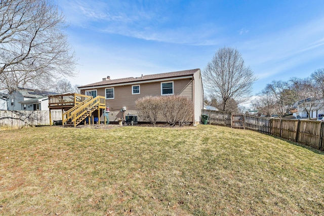 back of house featuring a fenced backyard and a lawn