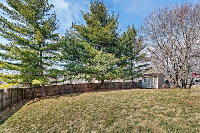 view of yard featuring a storage shed, an outdoor structure, and a fenced backyard