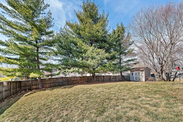 view of yard with an outbuilding, a storage shed, and a fenced backyard