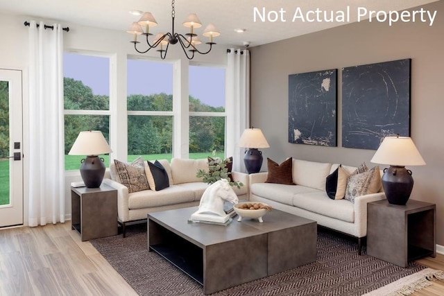 living area featuring a wealth of natural light, a notable chandelier, and wood finished floors