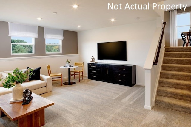 living area with light carpet, plenty of natural light, stairs, and recessed lighting