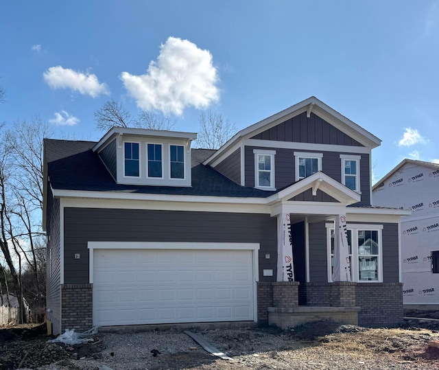 view of front of house featuring brick siding, board and batten siding, and an attached garage