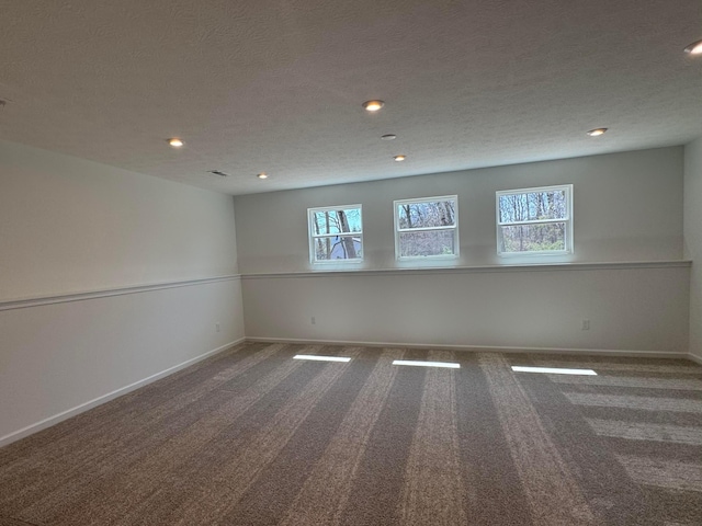 spare room with baseboards, carpet flooring, recessed lighting, and a healthy amount of sunlight
