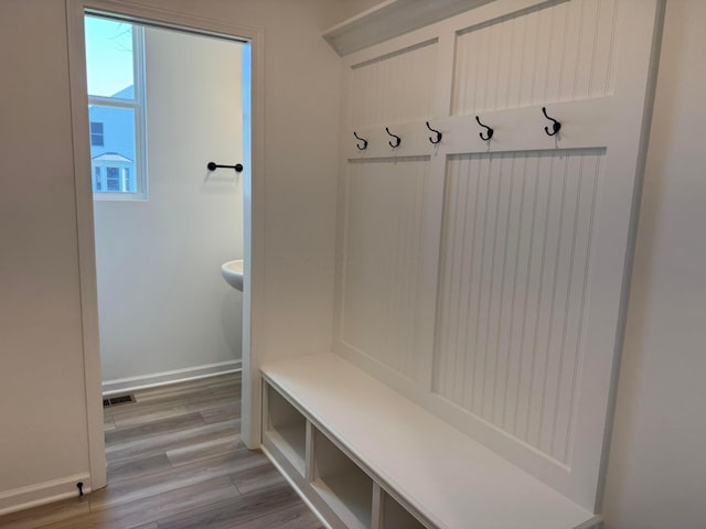 mudroom featuring light wood-style flooring, visible vents, and baseboards