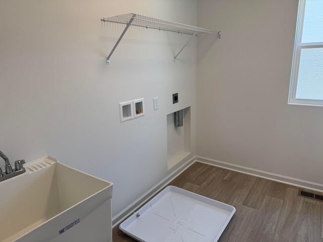 laundry room featuring laundry area, wood finished floors, visible vents, a sink, and washer hookup