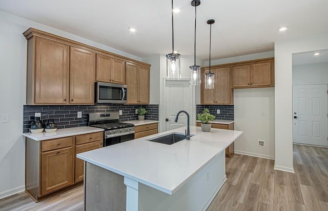 603 Mill Stone Dr Lot 2257, Sunbury, OH 43074 - kitchen with appliances with stainless steel finishes, a sink, brown cabinetry, light wood-type flooring, and backsplash