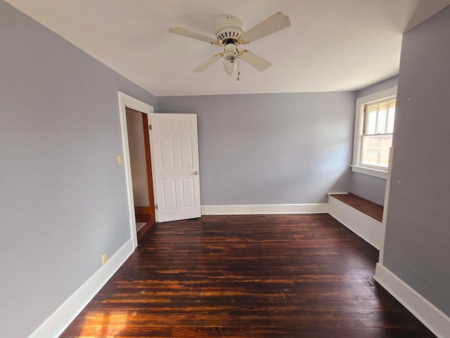 unfurnished room featuring ceiling fan, baseboards, and wood finished floors