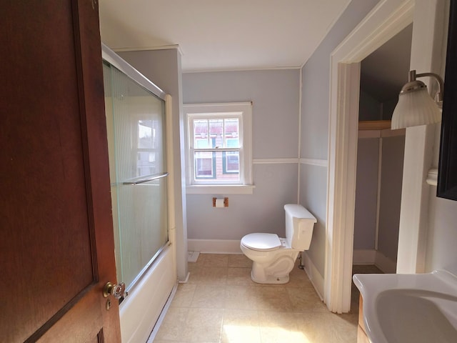 full bath with enclosed tub / shower combo, tile patterned floors, toilet, and baseboards