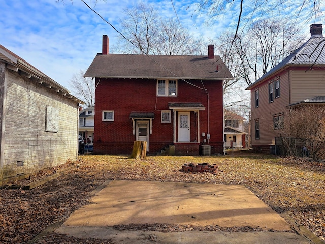 view of front of property with brick siding and a chimney