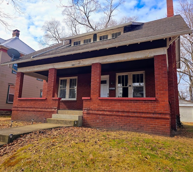 bungalow-style house with a porch, brick siding, and a chimney