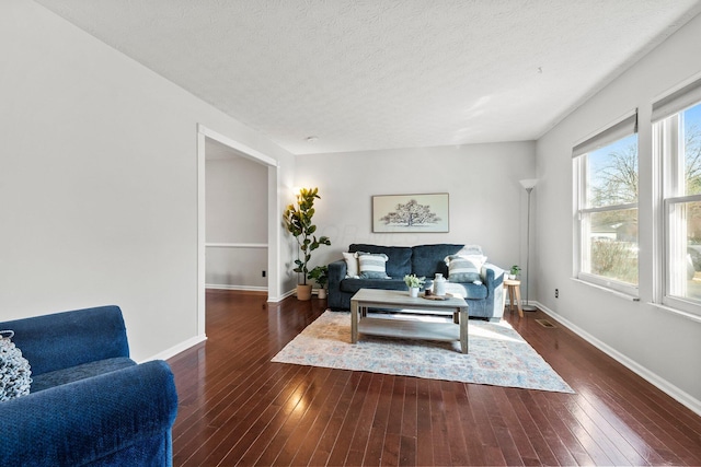 living room with visible vents, a textured ceiling, dark wood-type flooring, and baseboards