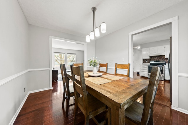 dining space featuring dark wood-style floors and baseboards