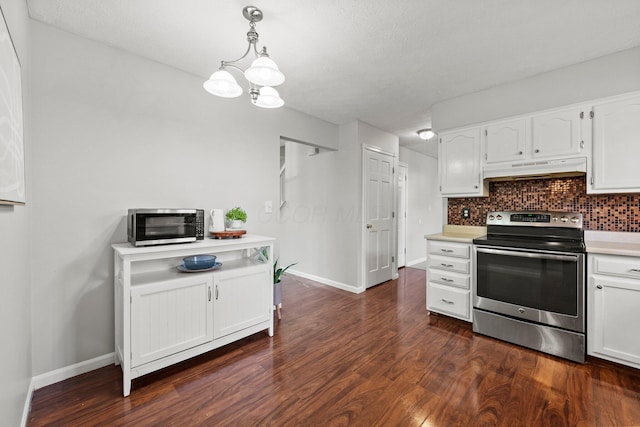 kitchen featuring dark wood finished floors, light countertops, under cabinet range hood, appliances with stainless steel finishes, and tasteful backsplash