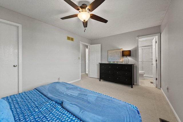 bedroom with visible vents, baseboards, carpet floors, ensuite bathroom, and a ceiling fan