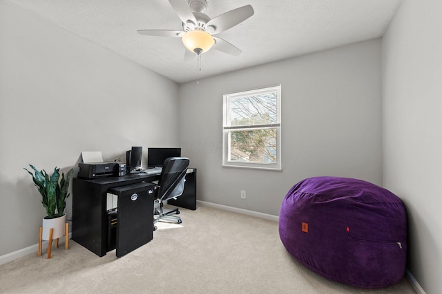 carpeted office with a ceiling fan, baseboards, and a textured ceiling