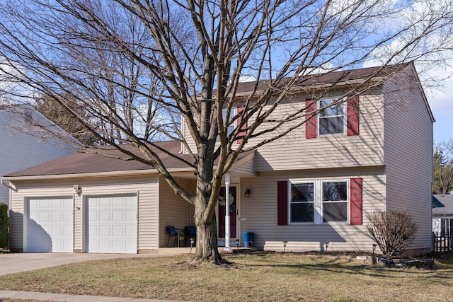 colonial home with a front yard, concrete driveway, and an attached garage