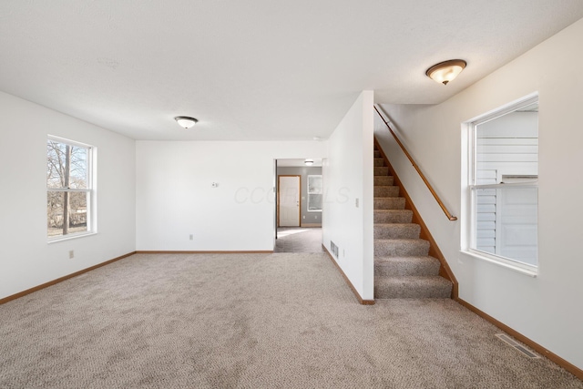 interior space featuring visible vents, baseboards, and stairs