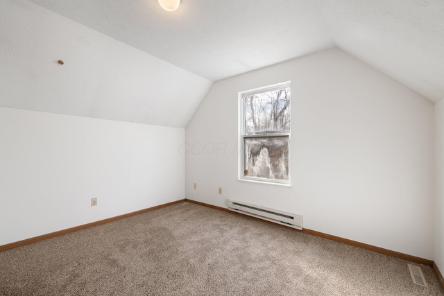 additional living space featuring lofted ceiling, baseboard heating, visible vents, and baseboards