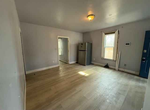 interior space featuring baseboards and light wood-style floors