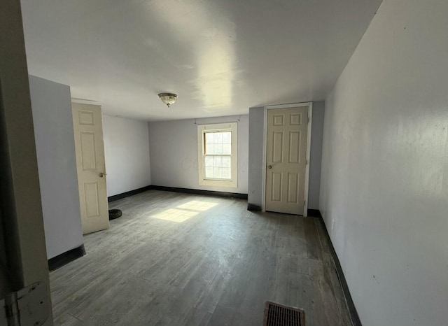 interior space with visible vents, baseboards, and wood finished floors