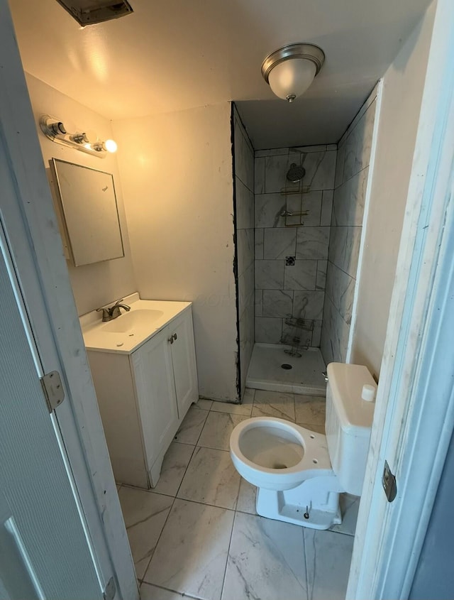 bathroom with toilet, marble finish floor, a stall shower, and vanity