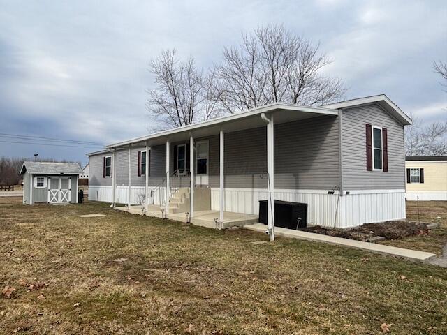 exterior space featuring an outbuilding, a shed, and a lawn