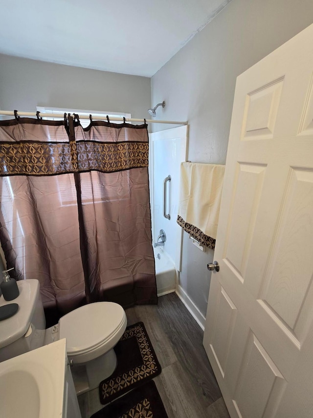 bathroom featuring toilet, shower / tub combo with curtain, and wood finished floors