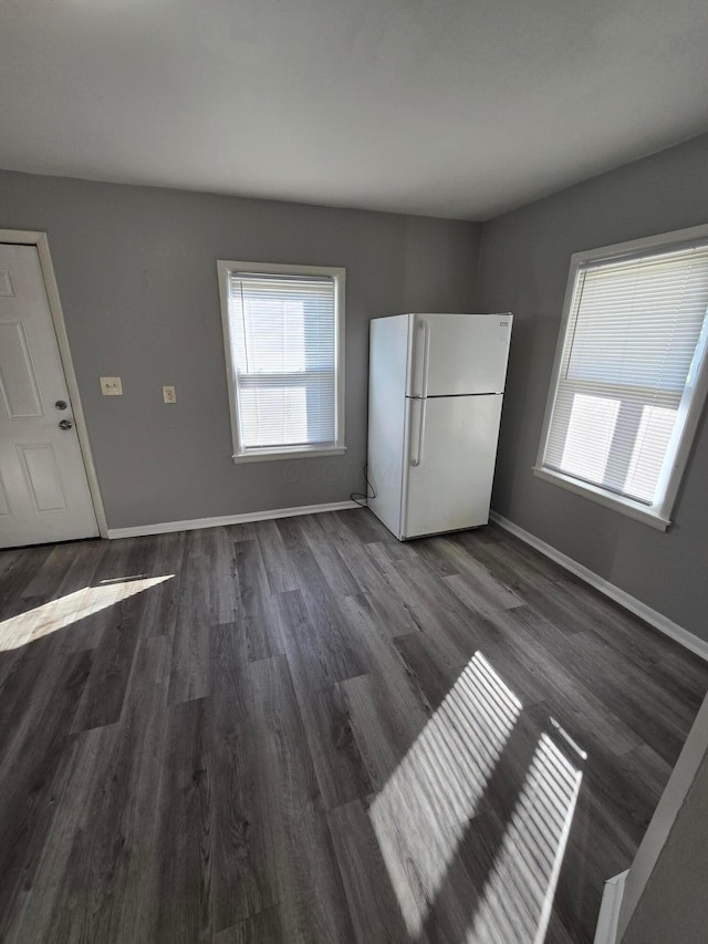 interior space with a wealth of natural light, baseboards, and freestanding refrigerator