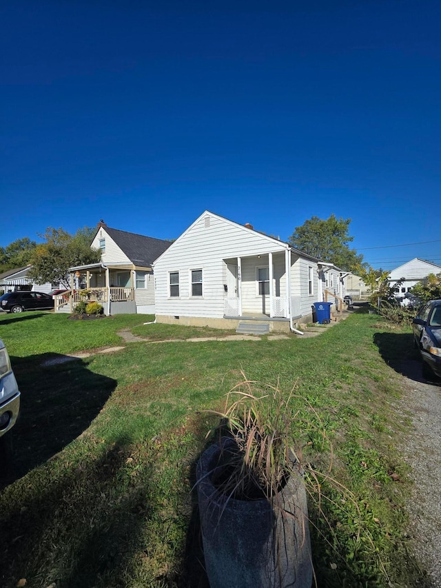 rear view of property with crawl space and a lawn