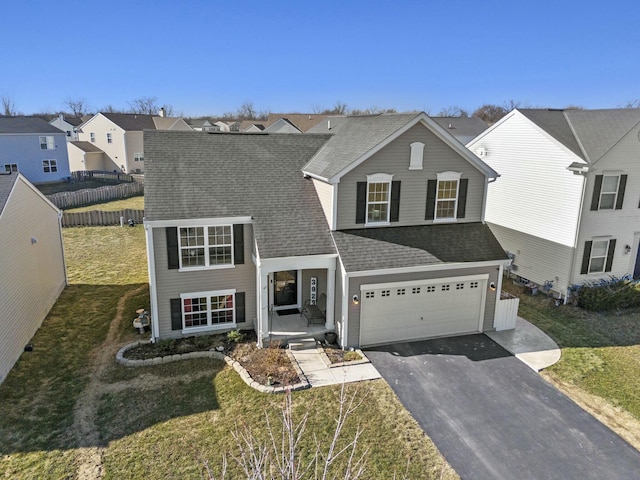 traditional-style house with a front lawn, aphalt driveway, a residential view, roof with shingles, and an attached garage