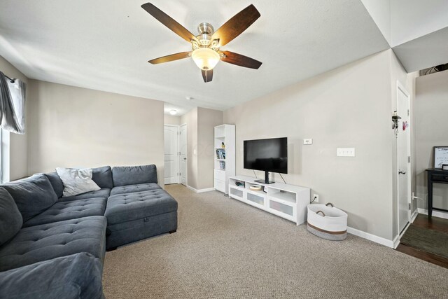 carpeted living room featuring baseboards and ceiling fan