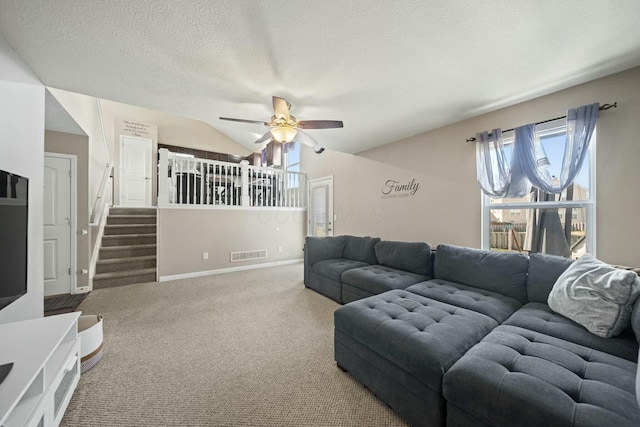 living area with visible vents, stairway, carpet flooring, a textured ceiling, and a ceiling fan