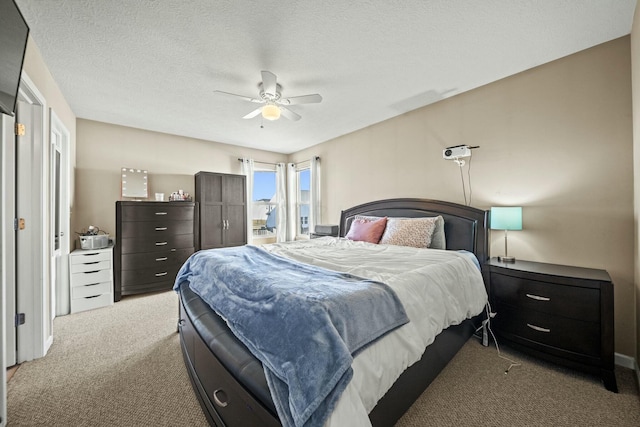 carpeted bedroom with a textured ceiling and ceiling fan